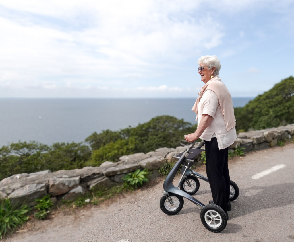 Dame med rollator på promenad med utsikt