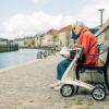 Dame sitter på benk med byACRE rollator på siden